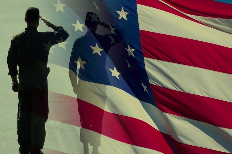 silhouette of a military member saluting the flag